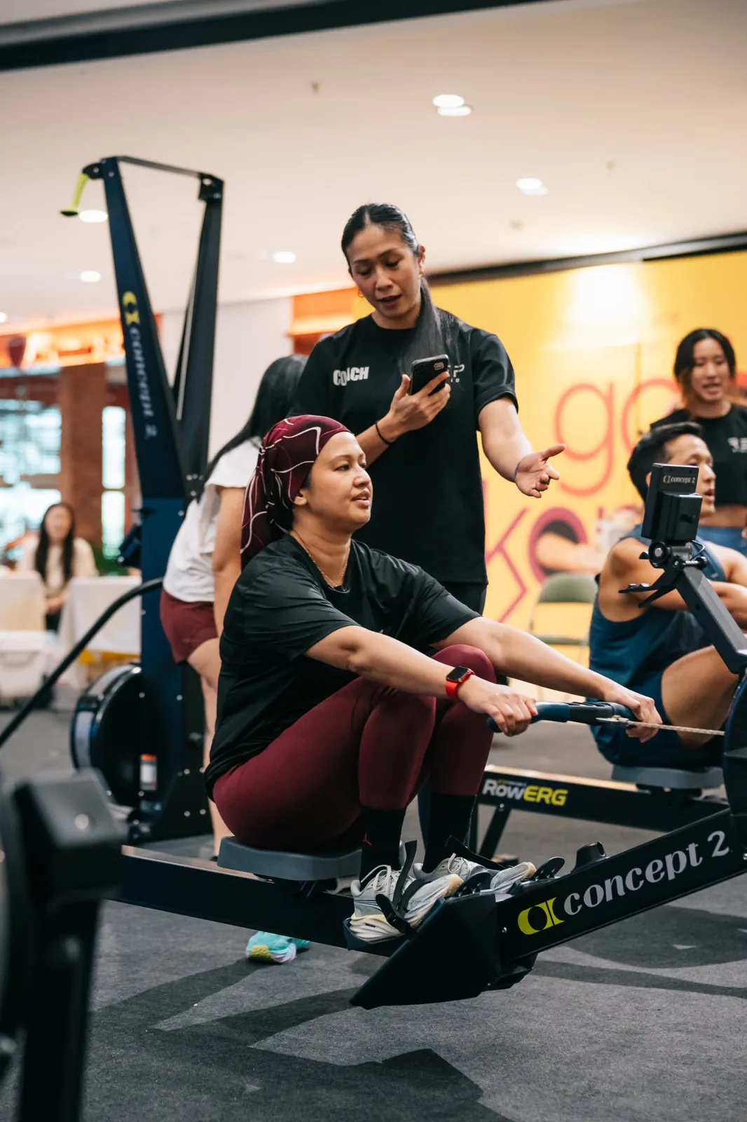A coach talking an athlete through the row