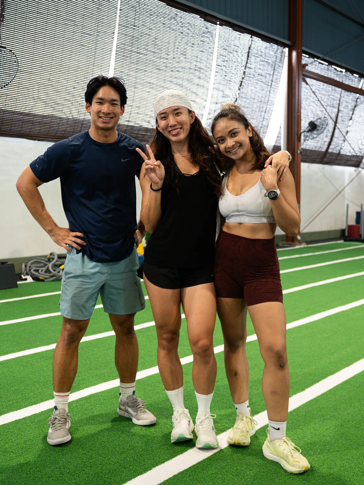 Three friends posing on the turf after class