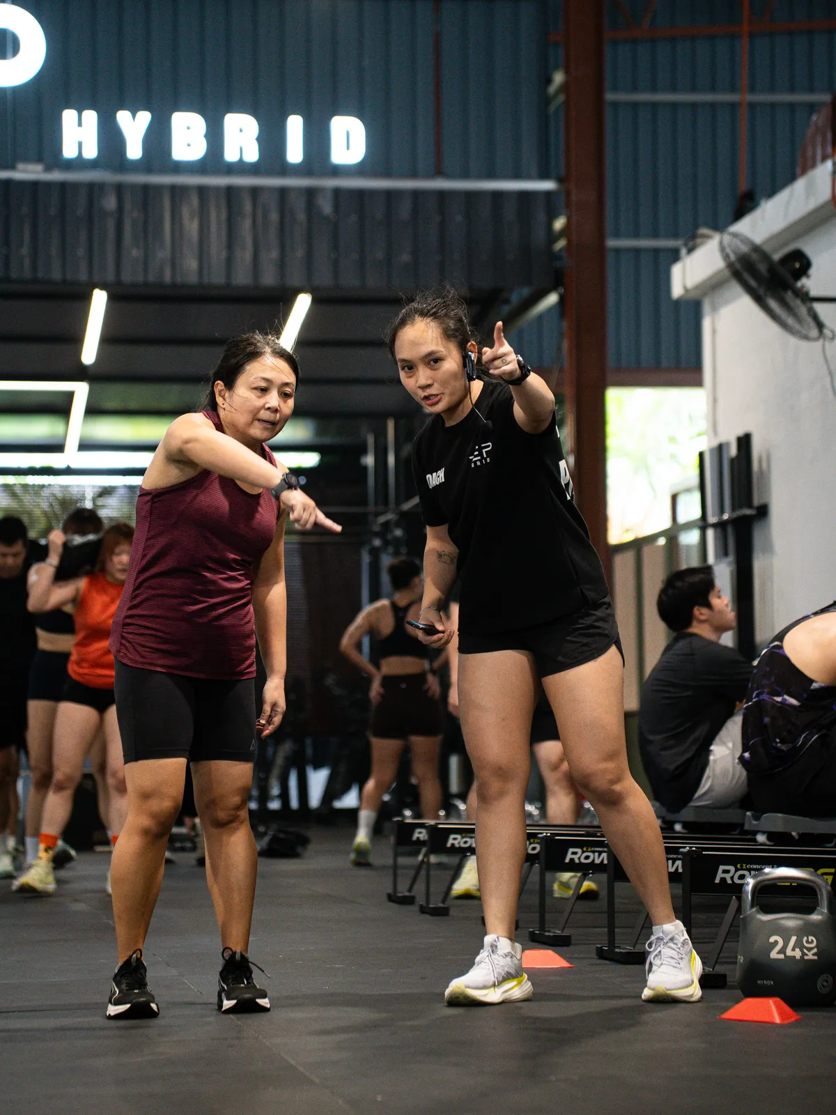 A coach and a member pointing at the camera