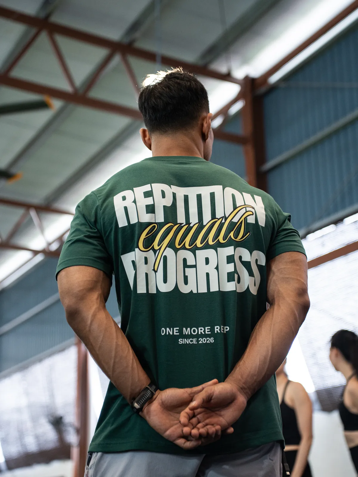 The back of a Repetition Equals Progress tee