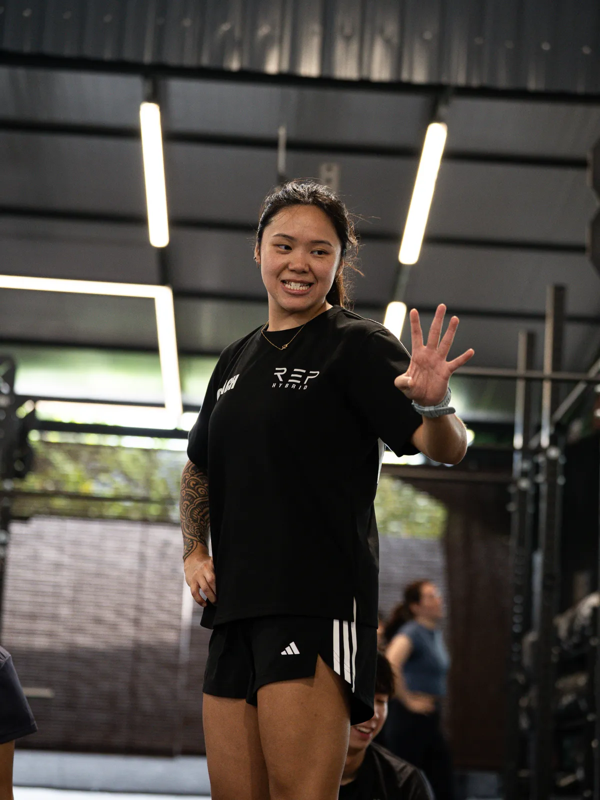 A coach in the REP tee waving to the camera